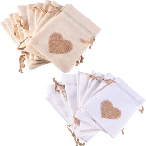May include: Two sets of 10 small burlap drawstring bags with a heart-shaped design. One set is natural beige and the other is white. Each bag has a brown burlap heart sewn on the front.