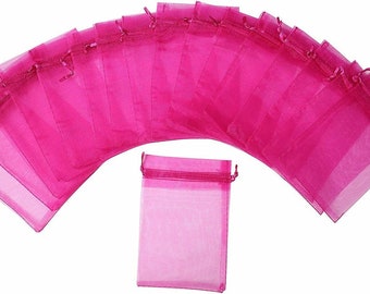 May include: A set of 15 pink organza gift bags with drawstrings. The bags are arranged in a semi-circle with one bag in the center.