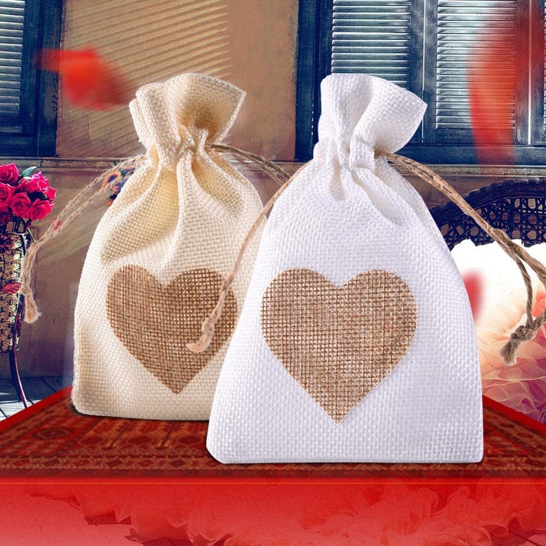 May include: Two small burlap drawstring bags with heart-shaped burlap patches. One bag is natural beige and the other is white.