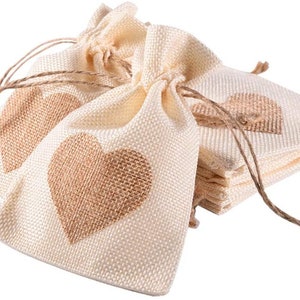 May include: A stack of small, cream-colored burlap bags with brown heart designs. The bags have drawstrings and are perfect for small gifts or favors.