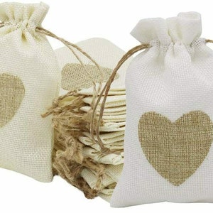 May include: A set of 12 small, white burlap drawstring bags with a brown heart design. The bags are perfect for packaging small gifts or favors.