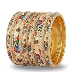 May include: A set of five gold bangles featuring a white enamel surface decorated with colorful floral patterns and elephant motifs. Each bangle is bordered by a thin line of small, clear stones, with a polished gold interior finish.