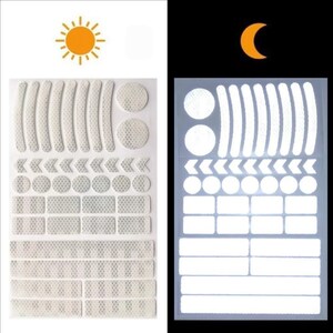 May include: A sheet of white reflective stickers for bicycles. The stickers are in various shapes, including circles, arrows, and rectangles. The stickers are designed to be visible in both daylight and nighttime.