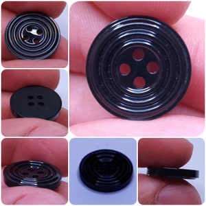 Puede incluir: Cuatro botones negros con un diseño de círculos concéntricos. Los botones tienen cuatro agujeros en el centro.