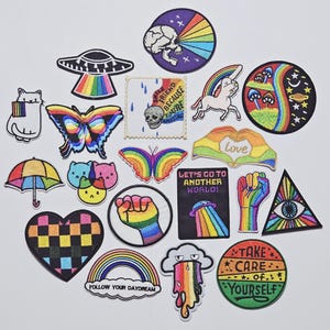 Peut inclure: Une collection de patchs brodés colorés avec divers motifs, dont un arc-en-ciel, des papillons, un chat, une licorne et des textes tels que "Follow Your Daydream" et "Take Care of Yourself".