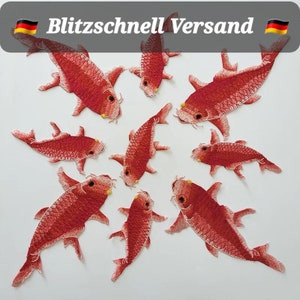 Könnte beinhalten: Neun rote gestickte Fisch-Patches mit gelben Augen. Die Patches befinden sich auf einem weißen Hintergrund.