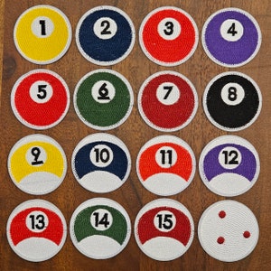 Könnte beinhalten: Set mit 15 gestickten Filzpatches mit den Billardball-Nummern 1 bis 15 sowie einem leeren Patch mit drei roten Punkten. Die Patches sind rund und haben einen weißen Hintergrund mit schwarzen Umrandungen. Die Zahlen sind schwarz und die Punkte rot.