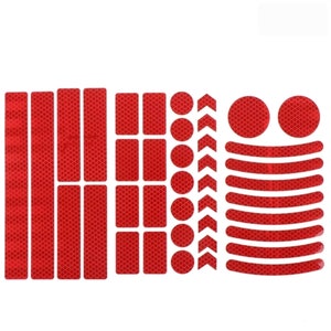May include: A set of red reflective stickers for bicycles. The set includes various shapes, such as long strips, rectangles, circles, and arrows. The stickers are designed to increase visibility and safety on the road.