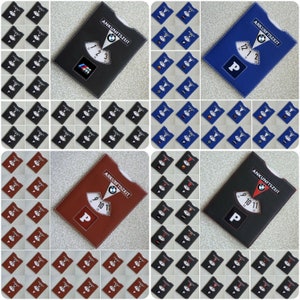 May include: A set of 36 leather arrival time cards. The cards are in three colors: black, blue, and brown. Each card has a circular dial with numbers and a logo in the center. The text "ANKUNFTSZEIT" is printed on each card.