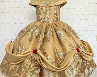 May include: A gold and red princess dress with a lace bodice and a satin skirt. The dress has a sweetheart neckline and off-the-shoulder straps. The skirt is full and flowing, and the dress is decorated with red roses.