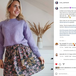 Pu&ograve; includere: Una donna indossa un maglione di lana color lavanda e una gonna con stampa floreale. La didascalia recita "#keinschnickschnackpullover" e include informazioni sul maglione, la lana e il modello.