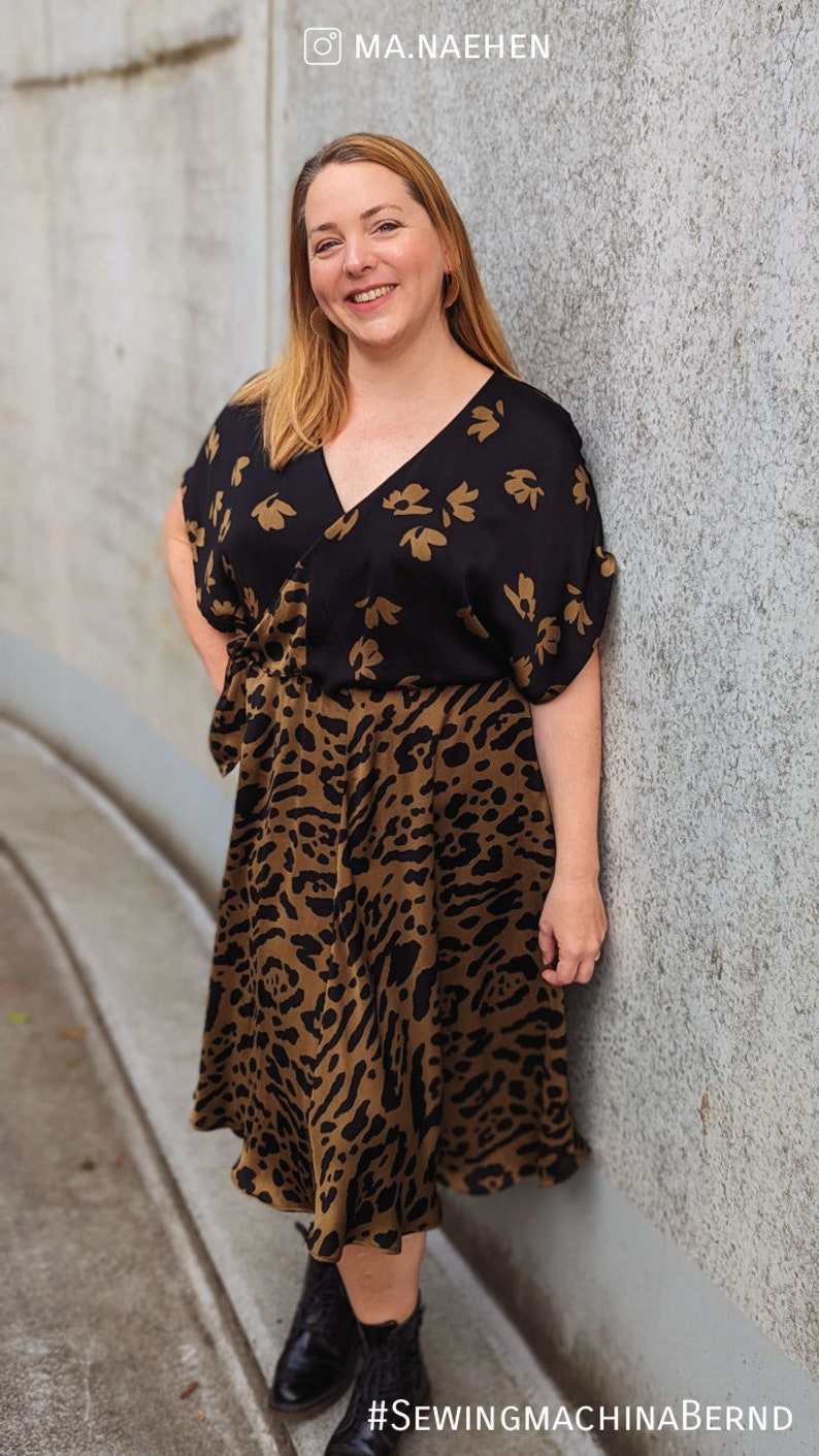 Puede incluir: Vestido estampado en negro y marr&oacute;n con cuello en V y mangas cortas. La parte superior del vestido es negra con un dise&ntilde;o floral dorado, y la parte inferior es marr&oacute;n con estampado de leopardo. El vestido llega a la rodilla.
