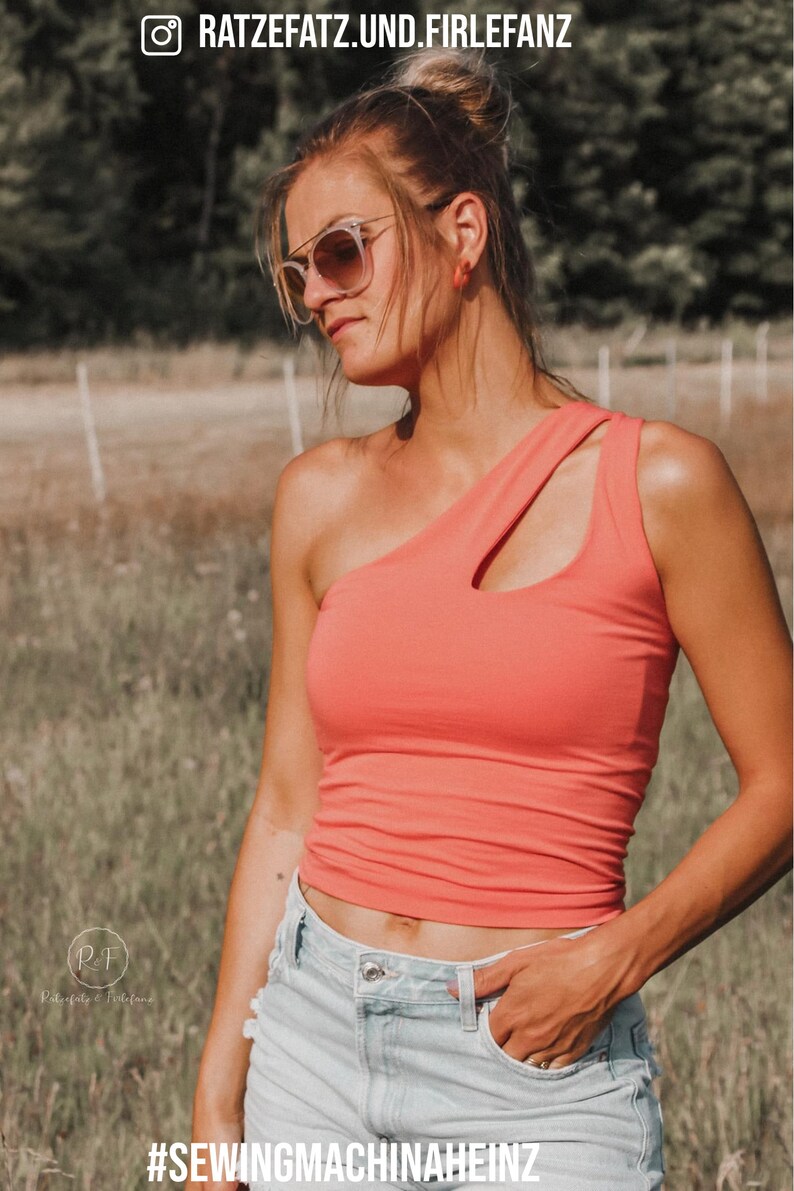 May include: A coral-coloured, one-shoulder tank top with a cutout detail. The top is paired with light-wash denim shorts. The image includes the text "RATZEFATZ.UND.FIRLEFANZ" and "#SEWINGMACHINAHEINZ".