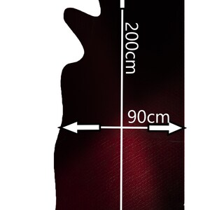 Op de afbeelding: Een donkerrode lederhuid met een onregelmatige vorm. De huid meet 200 cm in de lengte en 90 cm in de breedte.