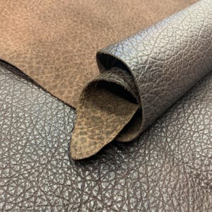 May include: Close-up of various brown leather textures. The image shows a flat piece of rough, light brown leather, a rolled-up piece of dark brown leather, and a textured, dark brown leather surface.