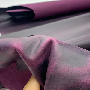 Peut inclure: Gros plan sur un tissu en cuir souple de couleur violette avec un effet ombré subtil, passant d'un violet foncé à une nuance plus claire.