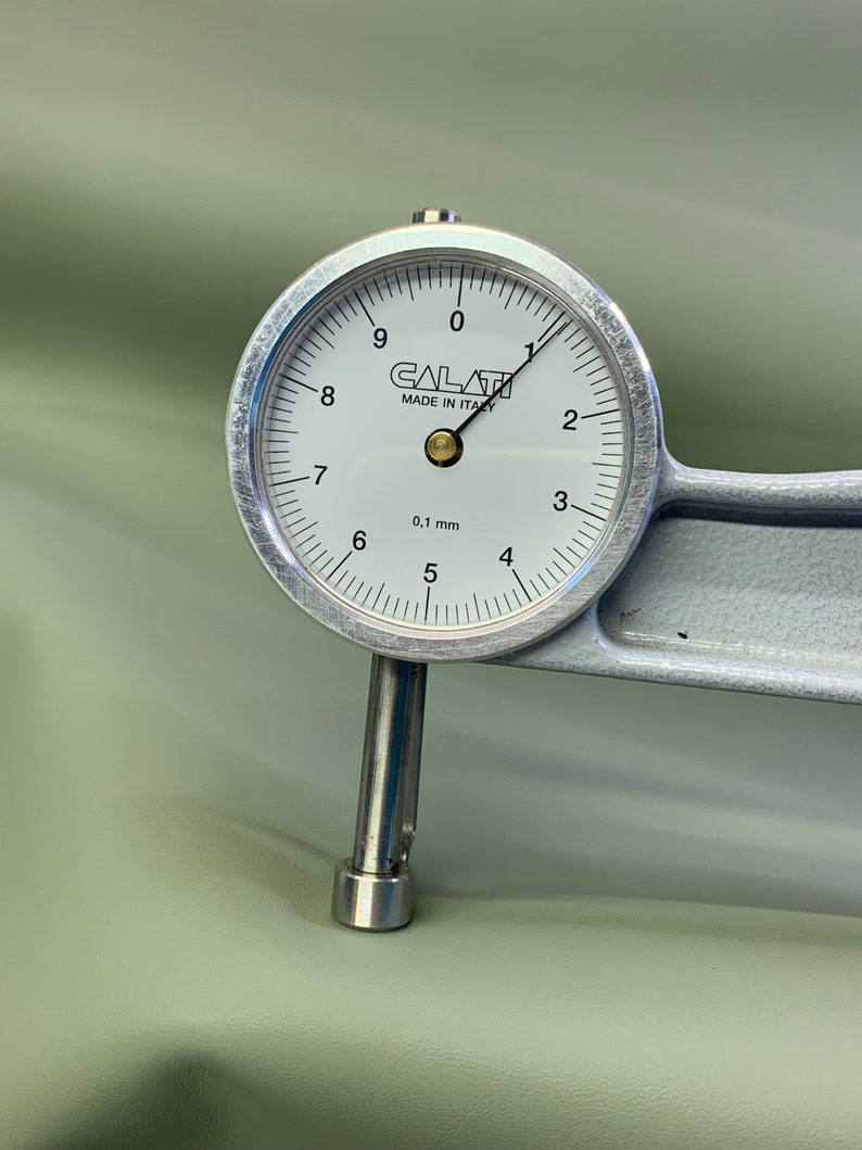 May include: A silver dial gauge with a white face and black markings. The gauge reads 0.1 mm and has the text "CALATI MADE IN ITALY" printed on the face.