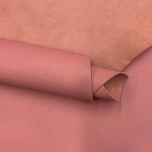 Peut inclure: Gros plan sur deux morceaux de tissu en cuir rose. Le morceau du haut est plié sur le morceau du bas, montrant la texture du matériau.