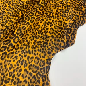 May include: A white ceramic mug with a black handle and the text "But First, Coffee" in a bold, black font. The mug is set against a blurred background, suggesting a cozy setting.