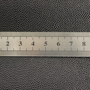 Op de afbeelding: Een close-up van een zilveren liniaal met zwarte markeringen. De liniaal is gemarkeerd in centimeters en millimeters. De liniaal is 10 centimeter lang.