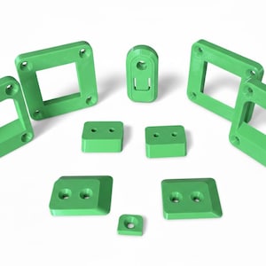 Peut inclure: Ensemble de composants imprimés en 3D vert vif, comprenant des cadres carrés avec des trous de fixation, des blocs rectangulaires et un petit élément arrondi. Les objets sont disposés sur fond blanc, présentant diverses formes et tailles.