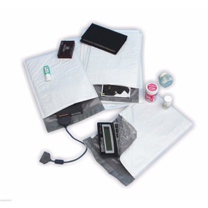 May include: White padded envelopes with various items inside, including a small black notebook, a black and silver electronic device, a green and white pen, a small white box, a pink and white container, and a white container.