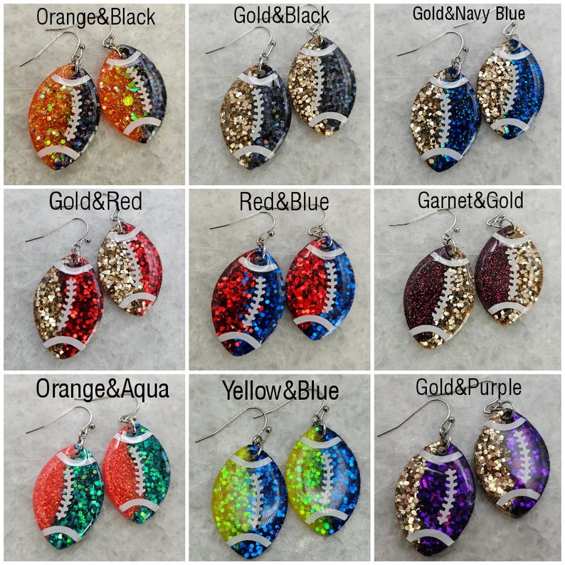 Op de afbeelding: Negen paar voetbalvormige oorbellen met glitter. Elk paar heeft een andere kleurencombinatie, waaronder oranje en zwart, goud en zwart, goud en marineblauw, goud en rood, rood en blauw, granaat en goud, oranje en aqua, geel en blauw en goud en paars.