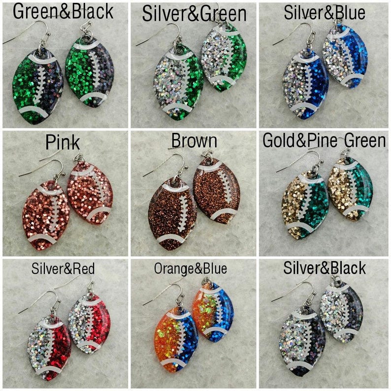Op de afbeelding: Negen paar voetbalvormige oorbellen met glitter en verschillende kleurcombinaties. De kleuren omvatten groen, zwart, zilver, blauw, roze, bruin, goud, pijnboomgroen, rood, oranje en wit.