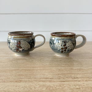 Pair of studio pottery mugs. Blue, beige and brown. Stamped ‘Norfolk Island’ on the bases.