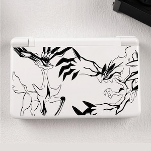 May include: A white handheld gaming console featuring a black line art graphic on the top cover. The design depicts two stylized creatures facing each other, with one resembling a deer-like figure and the other a sharp-clawed avian-like form.