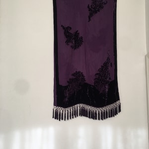 May include: A purple silk scarf with black velvet paisley designs and fringe.