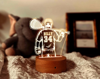 May include: A wooden base with a 3D printed design of a lacrosse player holding a lacrosse stick. The player is wearing a jersey with the name "Billy" and the number "34" on it.