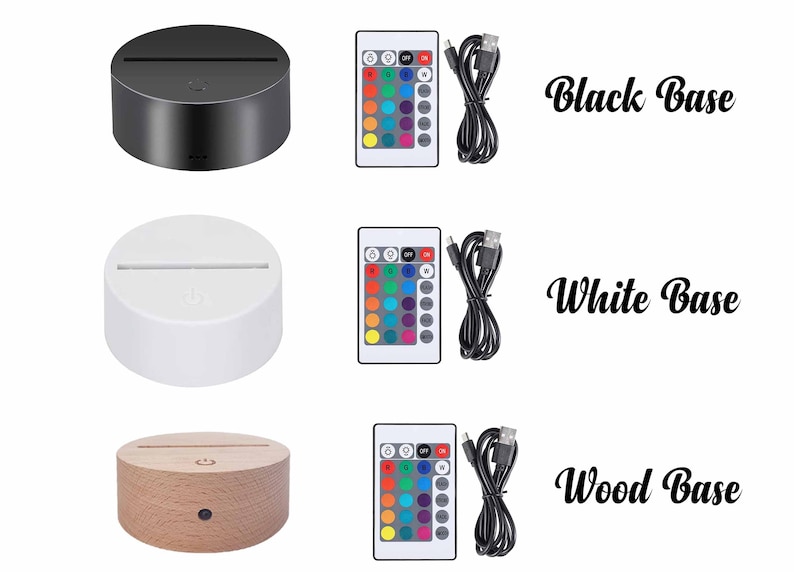 May include: Three images showing a 3D LED night light with a remote control and USB cable. The first image shows a black base, the second image shows a white base, and the third image shows a wood base.