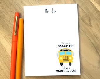 Puede incluir: Una tarjeta blanca con el texto "Mr. Jim" en la parte superior. La tarjeta tiene una ilustración de autobús escolar amarillo con el texto "You can't scare me I drive a school bus!"
