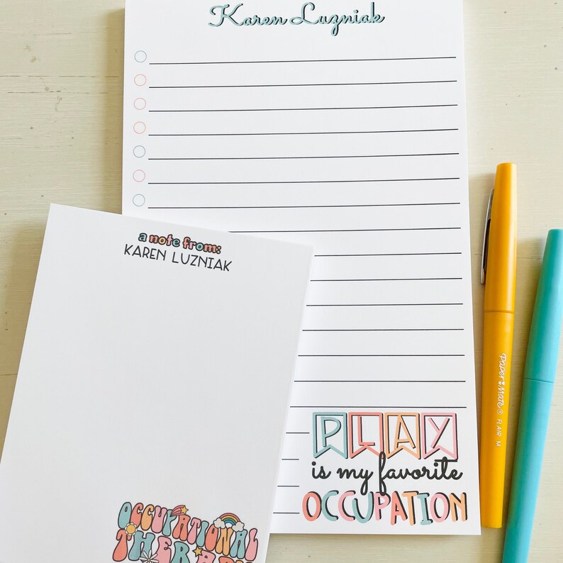 Peut inclure: Un bloc-notes blanc avec une page lign&eacute;e et une note de Karen Luzniak. Le bloc-notes a un graphique color&eacute; qui dit "Jouer est mon occupation pr&eacute;f&eacute;r&eacute;e".