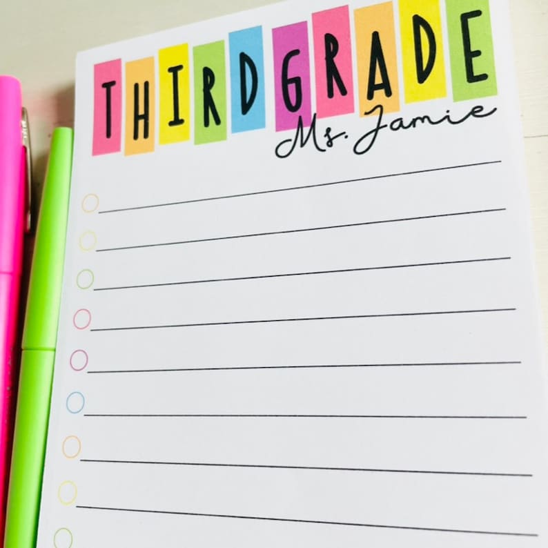 May include: A white notepad with a rainbow colored banner that says "THIRD GRADE" and "Mrs. Jamie". The notepad has a lined section with a checklist of circles.