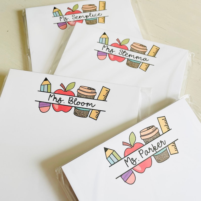 May include: Four white notepads with colorful illustrations of a pencil, apple, coffee cup, and ruler. Each notepad has a different teacher's name: Ms. Semplice, Ms. Stemma, Mrs. Bloom, and Ms. Parker.