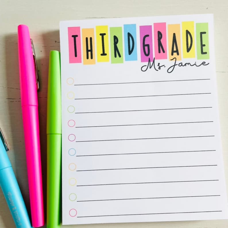 May include: A white notepad with a rainbow colored banner that says "THIRD GRADE" and "Ms. Jamie". The notepad has a checklist with 12 empty circles and lines for writing.