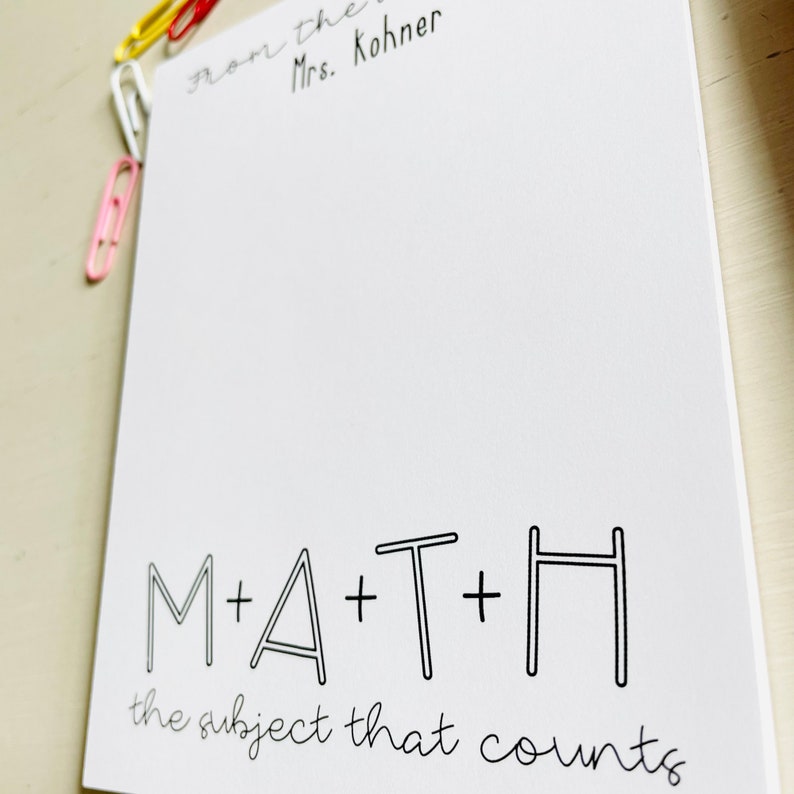 May include: White notepad with black text that reads "From the Mrs. Kohner" at the top and "M+A+T+H the subject that counts" at the bottom.