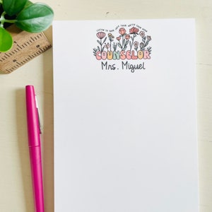 May include: White notepad with a floral design and the text "Listen to them, love them, watch them grow. Counselor Mrs. Miguel"