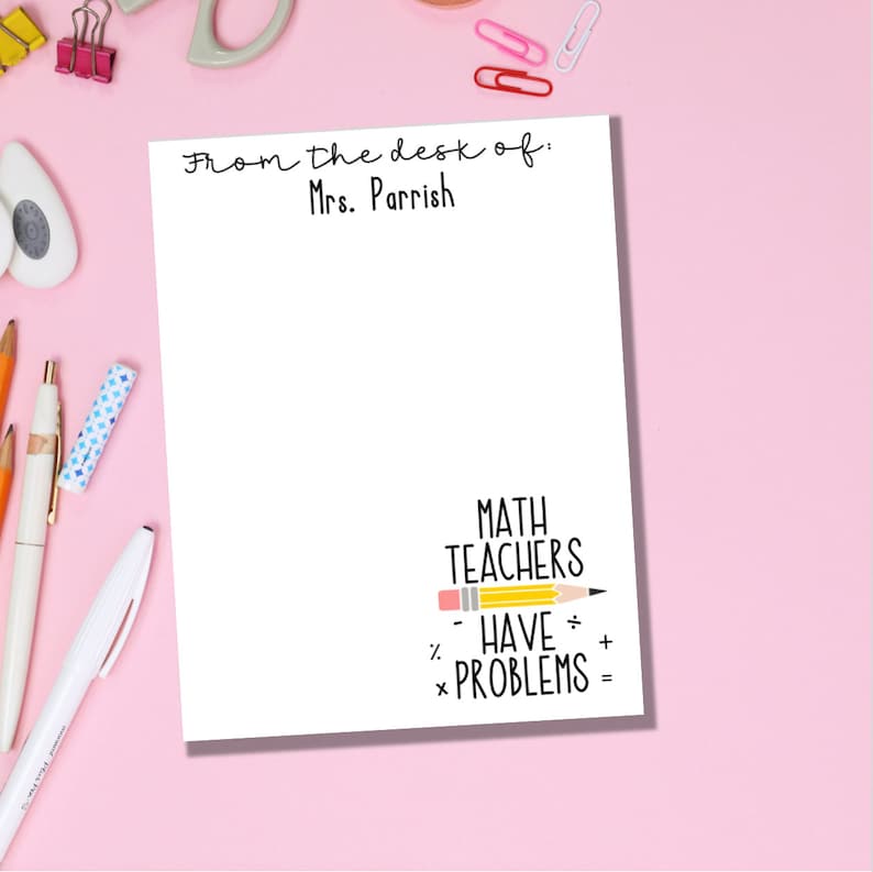 May include: White notepad with the text "From the desk of: Mrs. Parrish" at the top. The bottom of the notepad has the text "MATH TEACHERS HAVE PROBLEMS" with a yellow pencil drawn horizontally through the text. The pencil has a pink eraser.