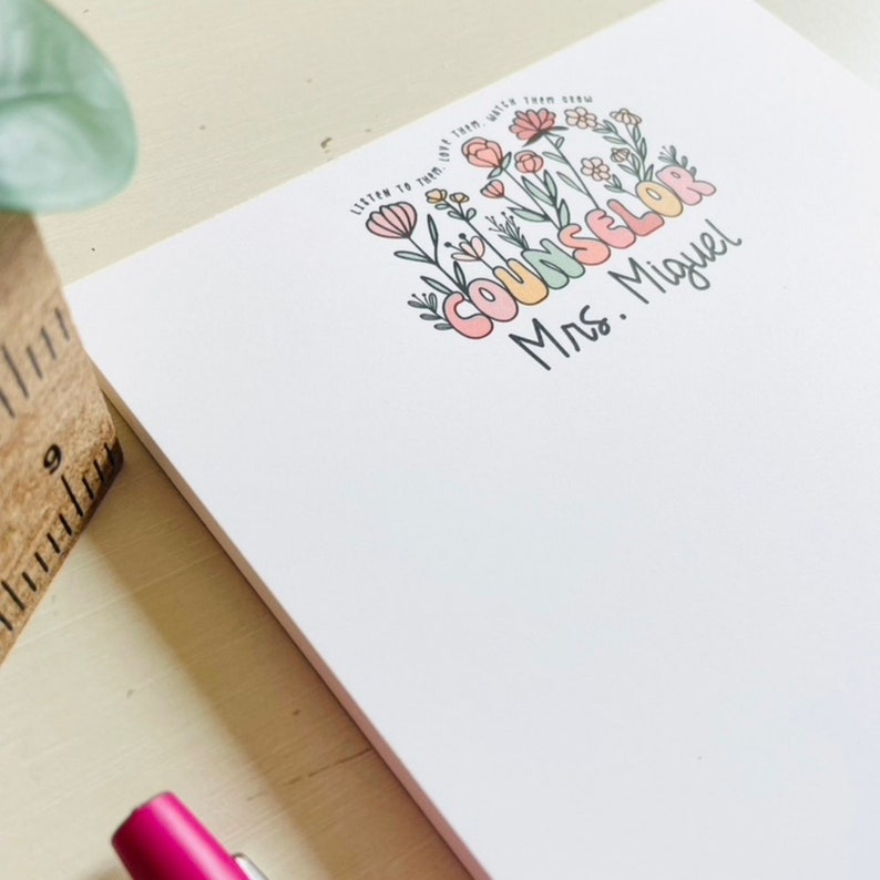 May include: A white notepad with a floral design and the text "Listen to them, help them, watch them grow. Counselor Mrs. Miguel".