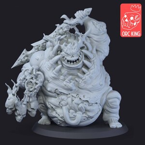 May include: A white unpainted resin miniature of a large, corpulent creature with a wide, toothy grin, horns, and a protruding belly. The figure holds a large sword overhead and a chain with skulls in the other hand. Includes an ORC KING logo.
