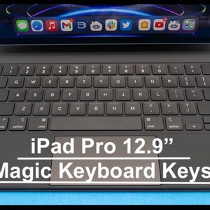 Könnte beinhalten: Ein schwarzes iPad Pro 12,9" Tablet mit einer schwarzen Magic Keyboard. Die Tastatur verfügt über ein Trackpad und eine Reihe von Funktionstasten.