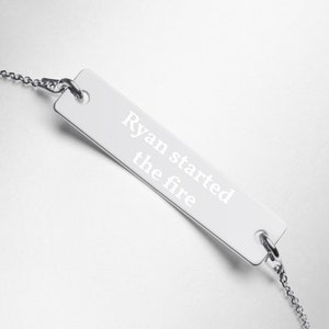 Puede incluir: Collar de plata con una etiqueta rectangular que dice "Ryan started the fire".