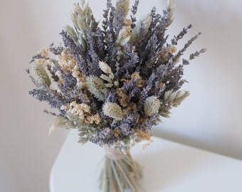 May include: A dried flower bouquet with lavender, wheat, and other dried grasses. The bouquet is tied with twine and is ready to be displayed in a vase.