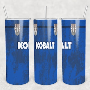 Puede incluir: Tres vasos de acero inoxidable con tapas y pajitas. Los vasos son azules con una textura de metal desgastado y la palabra "KOBALT" impresa en blanco.