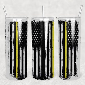 Könnte beinhalten: Drei Edelstahlbecher mit einem abgenutzten amerikanischen Flaggenmuster und einem dünnen gelben Streifen in der Mitte. Die Becher sind alle leer und haben Strohhalme.