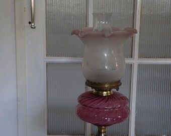 A Victorian Era Cranberry Glass and Cast Brass Oil Lamp