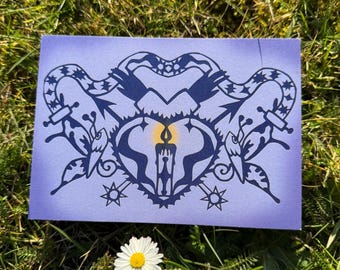 May include: A purple card with a black and white illustration of a heart with a candle inside. The heart is surrounded by two birds and a snake. The background is a gradient of purple and blue.